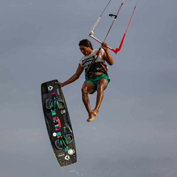 Kite Explorer Colombia - Kite Surf - Colombie - pratiquant de kite dans les air, soulevé par voile, et tenant d'une main sa planche
