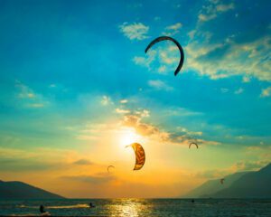 coucher de soleil avec un voile de kite surf en train de voler