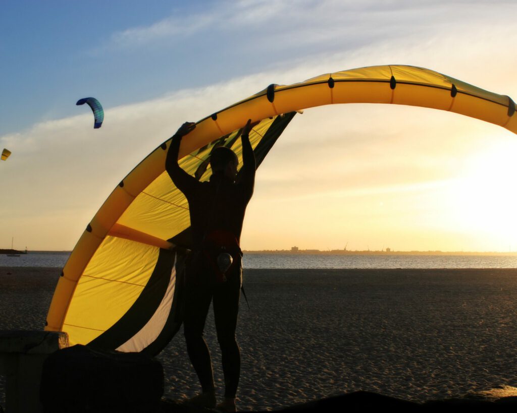 pratiquant de kitesurf en train de lever sa voile à bout de bras
