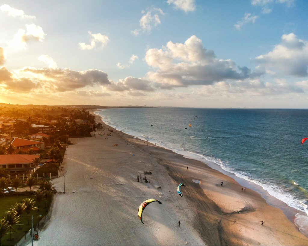 plage en colombie avec vue sur océan où l'on pratique le kitesurf , on voit des voiles sur la plage
