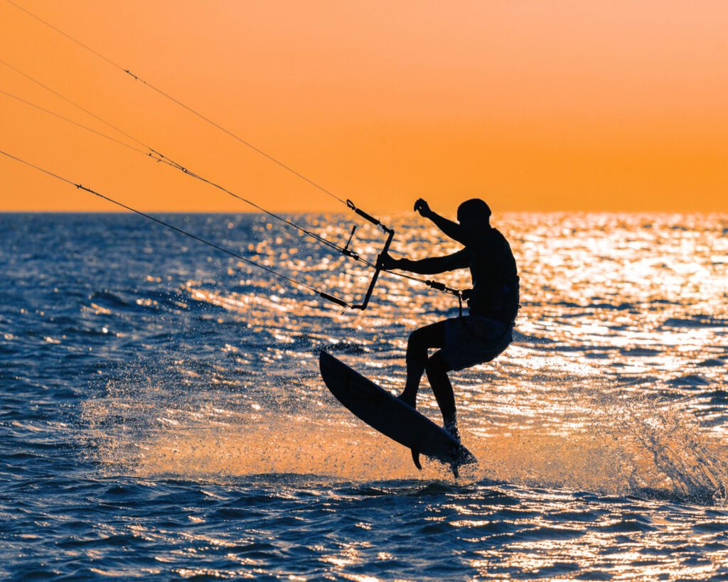 kitesurfeur en strapless au coucher du soleil en train de pratiquer