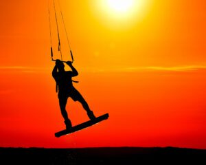 kitesurfeur au coucher de soleil en train de sauter hors de l'eau
