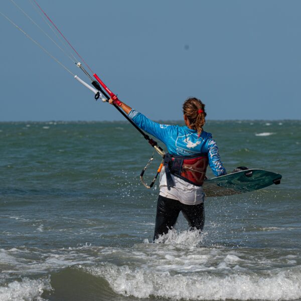 moniteur IKO de l'école kite explorer colombia entrant dans l'eau avec un kitesurf